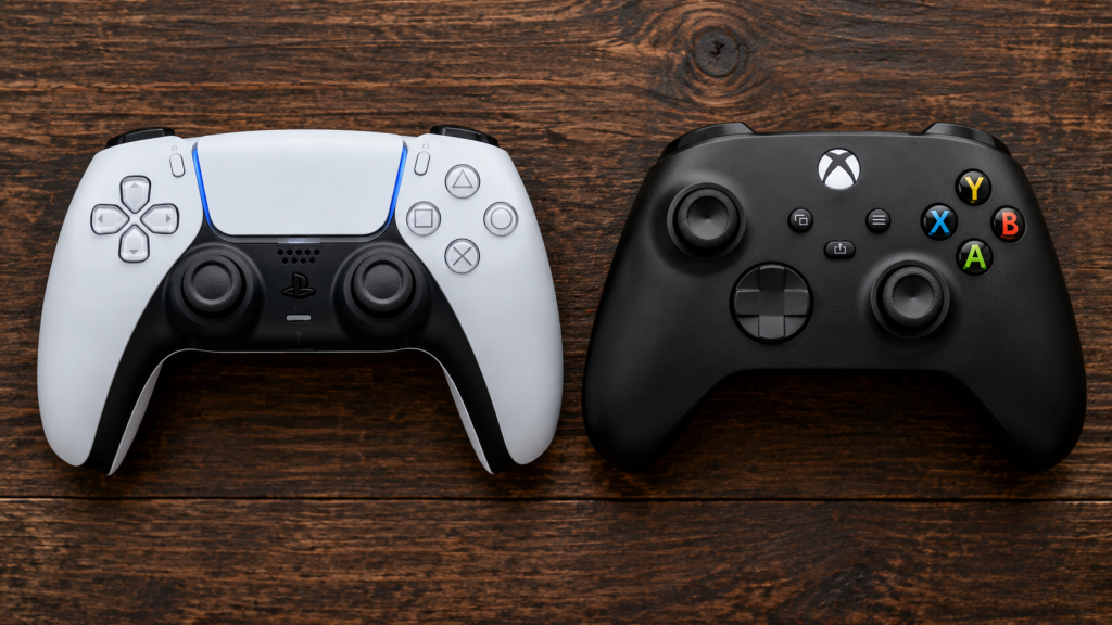 Kontroler PlayStation 5 dan Xbox Series X diletakkan berdampingan secara rapi di atas meja kayu, melambangkan pembagian pangsa pasar.